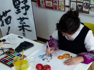 扇面和紙にトマトを描く萩原トミエ特別講師